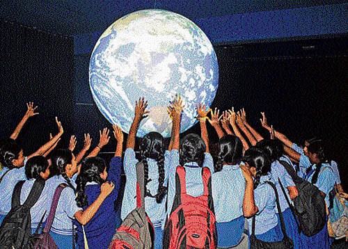 FEELING UNIVERSE Students experience 'Science on a Sphere' at the Visvesvaraya Industrial and Technological Museum on Monday. DH photo