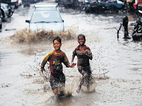 Boys run through a water-logged street after heavy monsoon rain in New Delhi on Saturday. Reuters