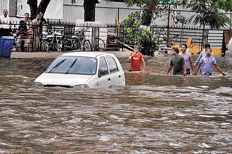 A vehicle moves through a street that was waterlogged following heavy rain in Jaipur on Saturday. PTI