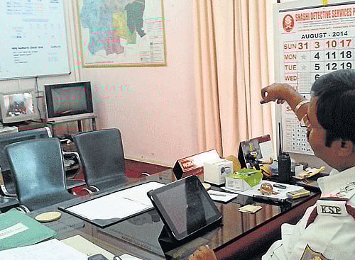 Inspector of N R Traffic police station Mohammed Irshad monitors the happenings in the station, from his chamber, in Mysore. DH PHOTO
