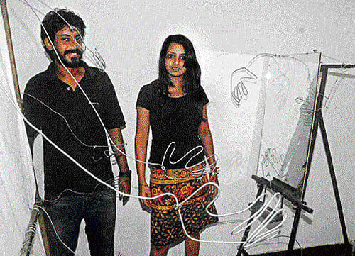 Artists Rahul K P and Neha Mehta demonstrate the symbolism of the Corridor of Hands at Rangoli Art Center on Wednesday. DH photo