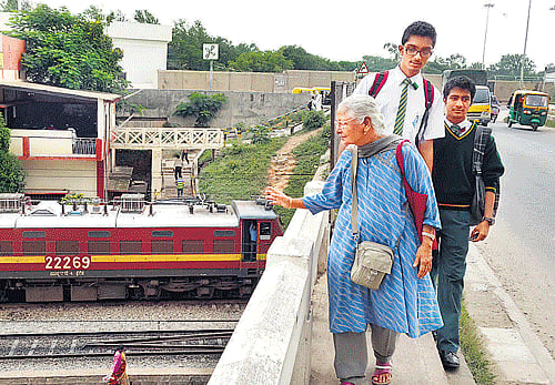 precarious: The narrow metre-wide foothpath on the Baiyappanahalli rail overbridge with its knee-high parapet wall. dh Photo
