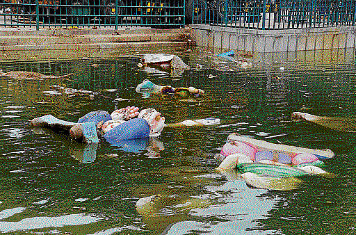 Ganesha idols lie uncleared in the tank beside Ulsoor Lake.