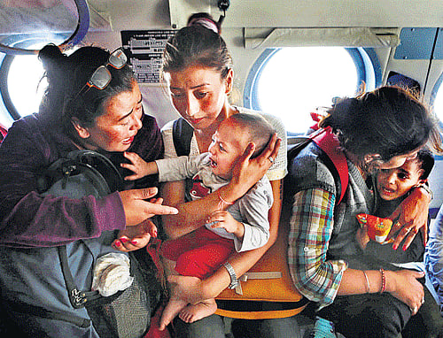 Helping hands : Tourists comfort their crying children inside an Air Force helicopter after being rescued from a flooded neighbourhood in Srinagar on Wednesday. PTI