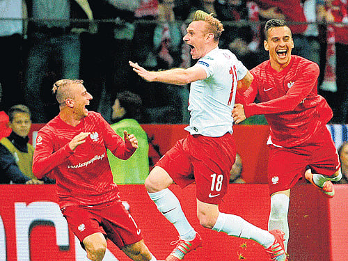 Poland's Sebastian Mila (centre) celebrates after scoring against Germany during their Euro 2016 qualifying match in Warsaw on Saturday. AP