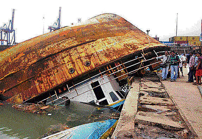 Fishermen watch their damaged boat, after cyclone Hudhud hit the eastern coast of the country, in Visakhapatnam on Monday.  Reuters