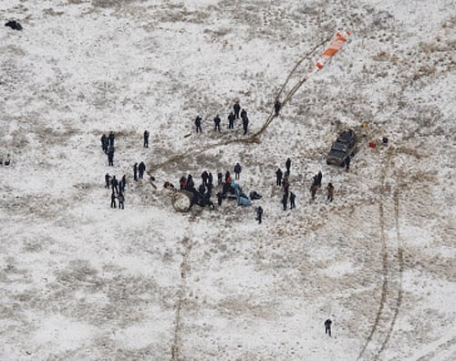 Ground support personnel stand at the landing site after the Soyuz TMA-13M spacecraft landed with Expedition 41 Commander Max Suraev of the Russian Federal Space Agency, NASA flight engineer Reid Wiseman and flight engineer Alexander Gerst of the European Space Agency near the town of Arkalyk, Kazakhstan, AP Photo