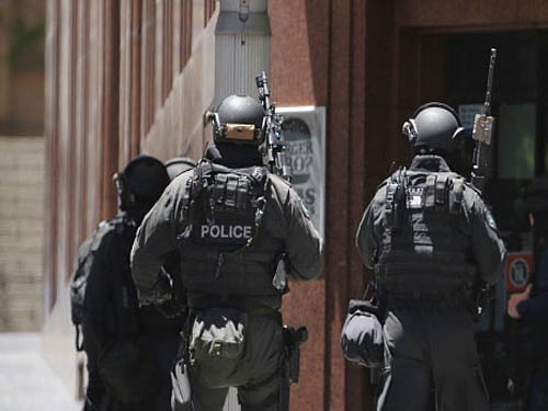 An armed man, who Monday took over 30 people hostage inside a cafe in Sydney's central business district, has demanded police provide an Islamic State (IS) flag to him and also said that he wanted to talk to Australian Prime Minister Tony Abbott. AP photo