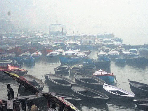 Boats anchored during a foggy and rainy day in Varanasi on Saturday. PTI