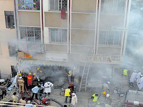 Fire and Emergency Services personnel douse the fire that broke out in a garment godown on  Veerapillai Street (near Commercial Street) in the City  on Saturday. DH photo