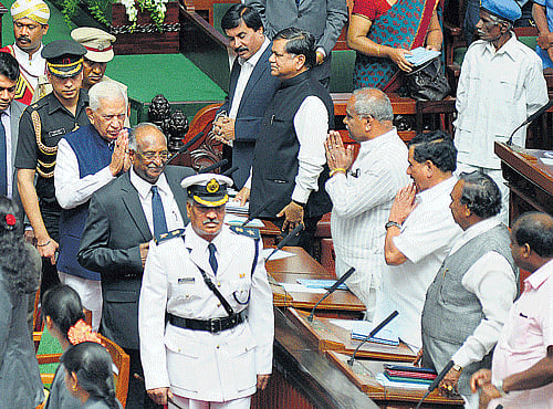 exchanging greetings: Governor Vajubhai Vala greets the Opposition members while leaving after his speech at the joint session of the State legislature in Bengaluru on Monday. Council Chairman D H Shankaramurthy, Deputy Speaker Shivashankar Reddy, Opposition leader Jagadish Shettar, MLAs Umesh Katti, K G Bopaiah, Opposition leader in the Council K S Eshwarappa and JD(S) floor leader H D Kumaraswamy are seen. dh Photo