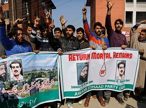 Kashmiri activists of Awami Itihaad party shout slogans as they hold banners with photographs of pro-independence leader Mohammed Maqbool Butt, right and former Kashmiri rebel Mohammed Afzal Guru during a protest in Srinagar, India, Monday, Feb. 9, 2015. AP photo