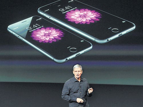 inspiring leader: Apple Chief Executive Tim Cook stands in front of a screen displaying the IPhone 6. Noting that Apple sold more than 34,000 iPhone 6s every hour, 24 hours a day, during the quarter, Cook, called it "historic" and the earnings "amazing." REUTERS