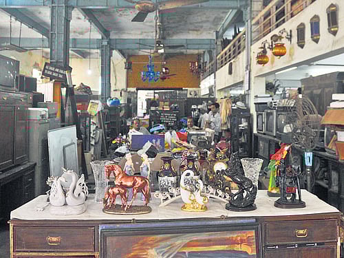 The auction house offers everything, from bric-a-brac to furniture to antiques.  (Below) Auction house's co-owner Arshad Salim with two items to come under the hammer on Sunday. Debasish Bhaduri