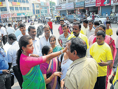 ZP President Pushpa Amarnath argues with a policeman at K R Circle during the rally held in Mysuru, on Sunday. DH PHOTO