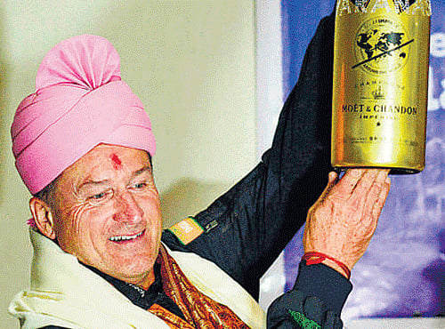 Andre Borschberg, one of the pilots of the solar-powered aircraft 'Solar Impulse II', holds a champagne bottle after landing in Varanasi onWednesday. AFP
