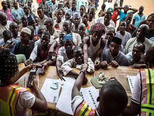 People wait to vote at a polling station in Abuja during presidential elections on March 28, 2015. Problems with new technology forced a 24-hour extension to the presidential election in Africa's most populous nation, Nigeria, and renewed Boko Haram violence hit the knife-edge vote. AFP PHOTO
