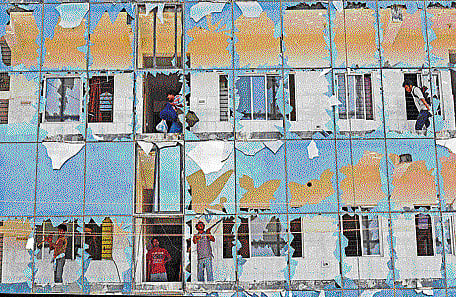 Lock, stock and barrel: Residents leave with their belongings as workers demolish this 'illegal' building built on Sarakki lake land on Thursday. DH photo/ S Manjunath