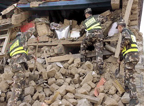 Police search ruins after a 7.9-magnitude earthquake hit Nepal on Saturday, in Gyirong county. Reuters photo