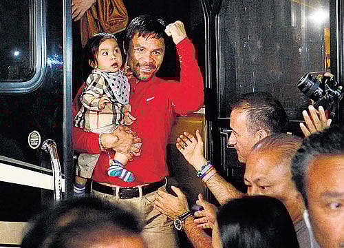 fist of fury Manny Pacquiao arrives with his son Israel at the at the Delano hotel in Las Vegas on Monday. The Filipino will take on Floyd Mayweather on Saturday. ap