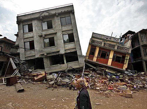 A Nepalese man walks past damaged buildings in Lalitpur, on the outskirts of Kathmandu, Nepal, Thursday, April 30, 2015. AP file photo