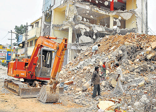 People collect metal items from the debris of a building demolished on the Banaswadi lake bed in the City. DH photo by B K Janardhan