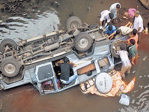 People search the mangled remains of the ill-fated vehicle on Saturday.PTI Photo