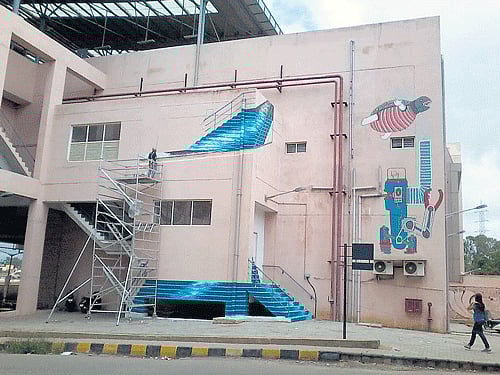 art in brick and mortar: Devika Shah works atop a high scaffolding to translate her notions about public art being able to make places and bring about identity to spaces of deadness. She identified the stairs as the means to bring this about. DH Photo