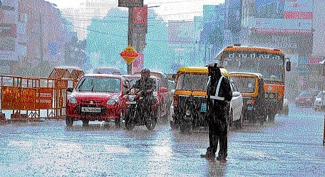 A traffic constable braves heavy rain while regulating vehicles in Mangaluru on Wednesday. DH PHOTO