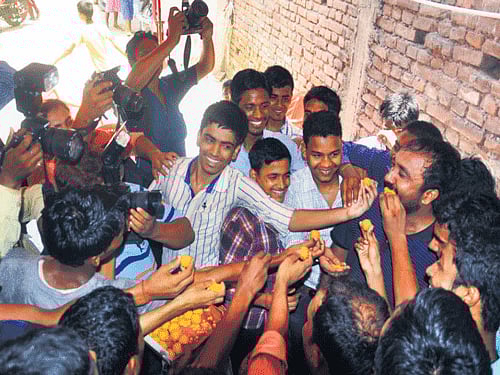Students vie with each other to offer sweets to Super 30 founder Anand Kumar in Patna on Thursday. DH Photo