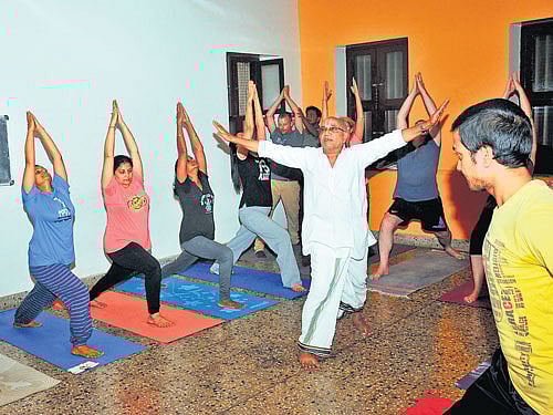 B&#8200;N&#8200;S&#8200;Iyengar teaches yoga to students in Mysuru. (Below) Yoga guru T&#8200;Krishnamacharya (standing on a student) performs asana along with his students at the erstwhile Yoga School, in Mysuru. (Courtesy- The Yoga of The Yogi, The Legacy of T&#8200;Krishnamacharya', biography by Kaushtub Desikachar).