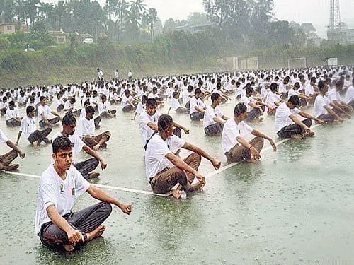 NCC cadets take part in a Yoga session, amidst rain, organised as part of International Yoga Day at  SAI turf ground in Madikeri on Sunday. DH photo