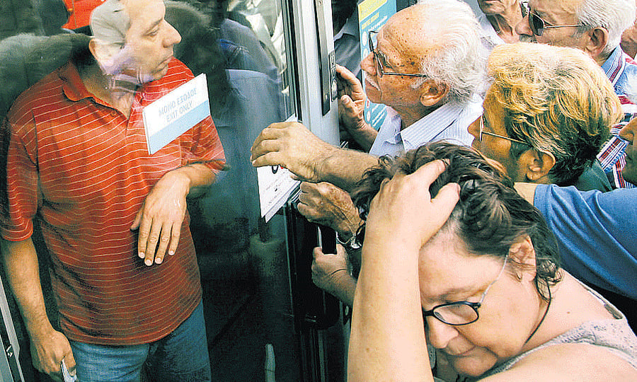 People wait outside a closed national bank hoping to get their pensions in Iraklio, Greece, on Monday. REUTERS
