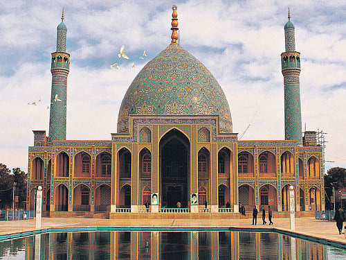 Golden past Agha Ali Abbas Mosque in Natanz, Iran; (right) spices and condiments at a market in Esfahan.