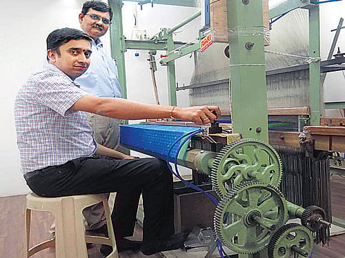 RmKV director N Manikavasagam demonstrates how to use the Modernised Pnuematic Handloom method on Tuesday. Standing towards his left is RmKV Managing Director K Sivakumar.