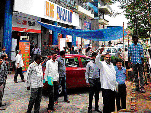 Bengaluru Urban district officials take ownership of Salarpuria Towers in Koramangala on Wednesday, saying it was built on government land. Additional Deputy Commissioner R Venkatachalapathy, Assistant Commissioner of Bengaluru South  L C Nagaraj and Bengaluru South Tahsildar Dr Dayanand are seen. DH Photo