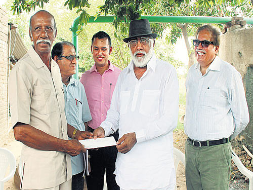Raman Parmar receives a cheque for supplying solar power to the grid in Gujarat.