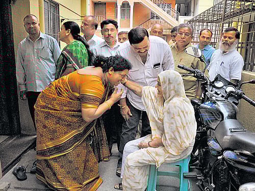 Hemalatha Satish, the BJP candidate for Rajmahal Guttahalli (ward number 64), canvasses for votes on Sunday. dh photo
