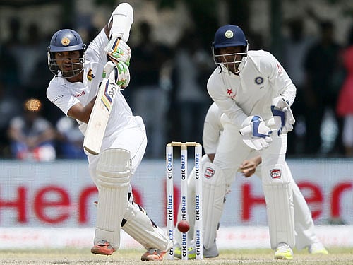 Sri Lanka's Dinesh Chandimal (L) plays a shot next to India's wicketkeeper Wriddhiman Saha during the first day of their first test cricket match in Galle, August 12, 2015. Reuters Photo.