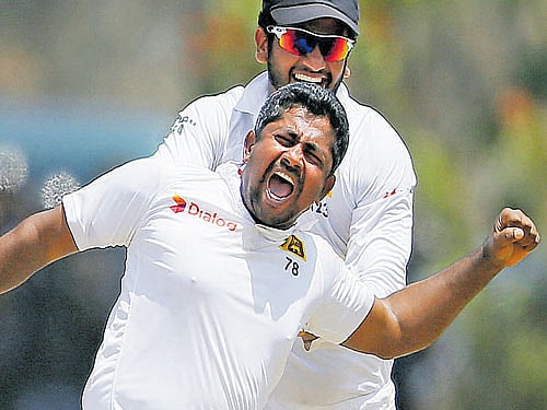 Wrecker-in-chief: Sri Lanka's Rangana Herath (front) celebrates with his teammate Dimuth Karunaratne after taking the wicket of India's Ajinkya Rahane on the fourth day of their first Test match in Galle on Saturday. REUTERS