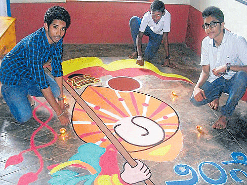 Students of St Aloysius High School Atul S K and Dhare Gowda with help from young artist Jeevan Acharya and under the guidance of art teacher John Chandran, drew the logo of Kannada literary meet in rangoli, measuring 10 ft X 15 ft, on the eve of the meet at Kateel on Thursday. DH photo