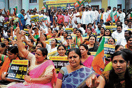 The BJP's corporators-elect, legislators from Bengaluru and former corporators stage a protest in front of the Town Hall on Friday, against the Congress-JD(S) alliance for the mayoral polls. (Below) An image being circulated by the BJP on social media, accusing the Congress of "betraying" people's mandate. dh photos