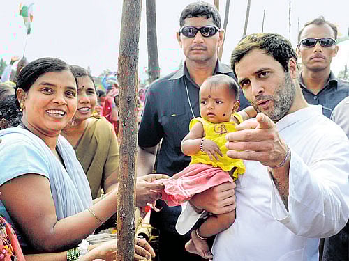 Congress vice-president Rahul Gandhi cuddles a child during a padayatra fromMaidur to Gudagur in Ranebennur taluk of Haveri district on Saturday. Chief Minister Siddaramaiah announced sops to farmers later. DH PHOTO