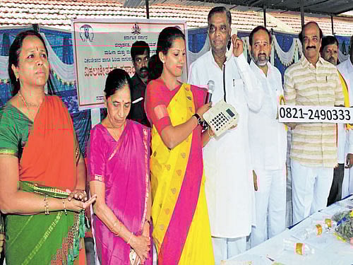 Revenue and District In-charge Minister V Srinivas Prasad makes a call at the launch of a helpline for specially-abled persons in Mysuru on Sunday. Mayor R Lingappa, Deputy Mayor Mahadevamma, ZP President Pushpa Amarnath, MUDA Chairman K R Mohan Kumar Deputy Director, Women and Child Development Department K Radha are seen. DH photo