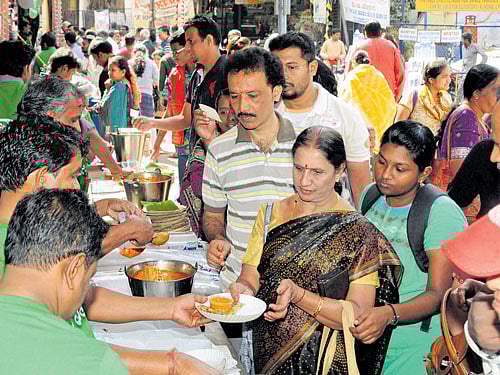 delicious Visitors enjoying the 'Avarekai Mela' and (right) 'kodubale'. Dh Photo by SK Dinesh