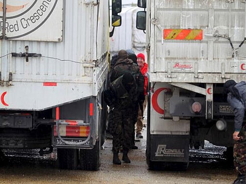 Rebel fighters inspect Red Crescent vehicles on their way to al Foua and Kefraya, in Idlib province, Syria, Reuters photo