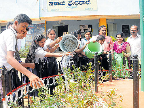 Students of Kommanal Government High School tending to plants. DH PHOTO BY SHIVAMOGGA NAGARAJ