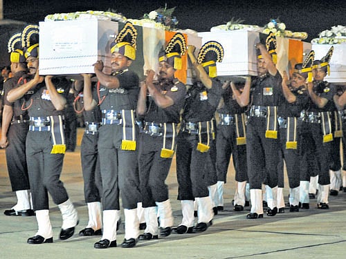 Armypersonnel carry themortal remains of the soldiers after their arrival at the HAL Airport in Bengaluru on Monday. DH PHOTO