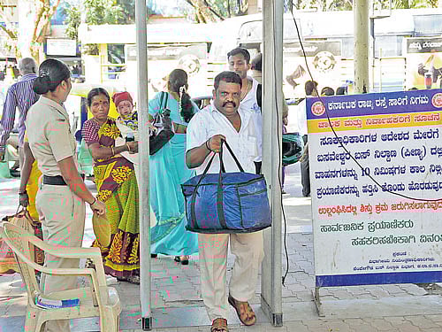 Passengers pass through the metal detector as part of security measures at the Kempegowda Bus Station in Majestic. DH FILE PHOTO