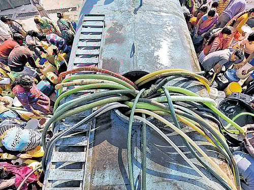 Residents with their empty containers crowd around a municipal tanker to fetch water in NewDelhi on Monday. REUTERS